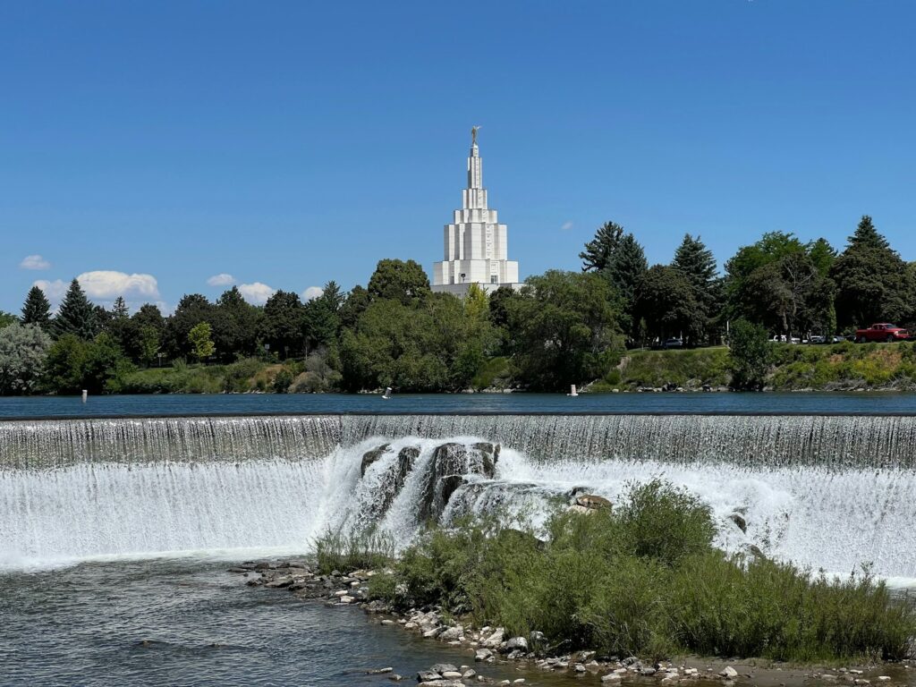 A large waterfall with a church in the background